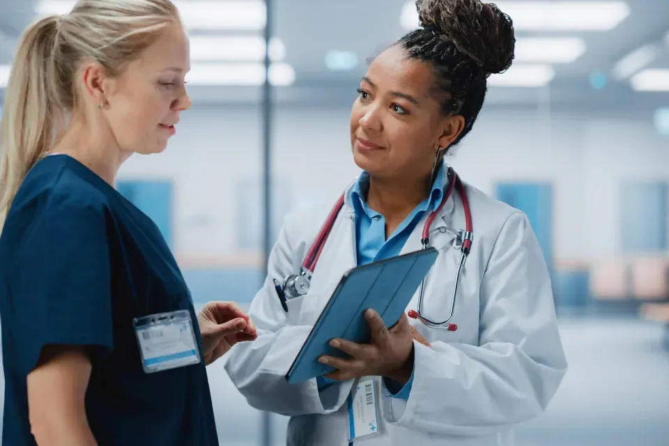 Nurse Practitioner Showing Patient Chart to Registered Nurse